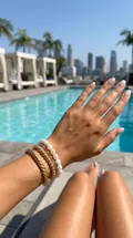 Armband-Stack am Pool mit Palmen — KI-generiert